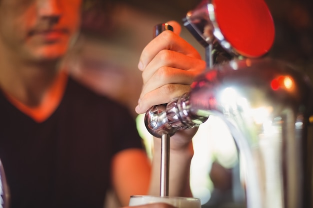 Close-up of bar tender filling beer from bar pump