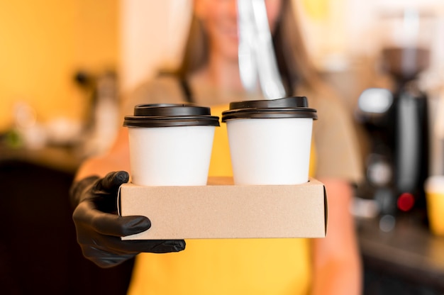 Free Photo close-up barista with gloves serving coffee