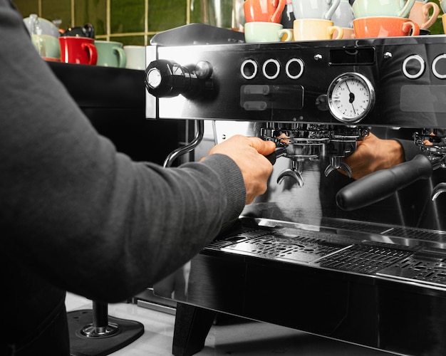 Close-up barista working with machine