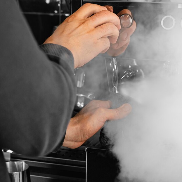 Close-up barista working with steam