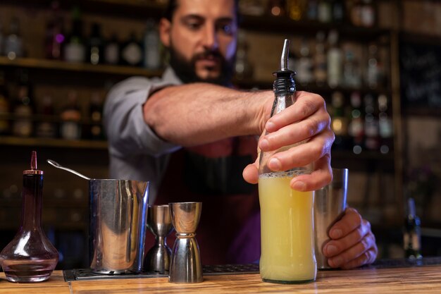 Close up on bartender and cocktail shaker