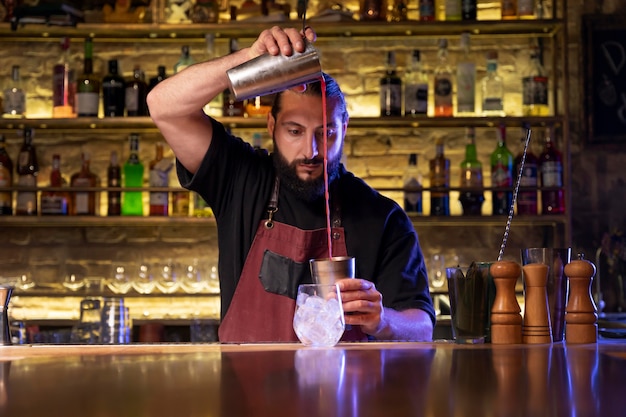 Close up on bartender and cocktail shaker