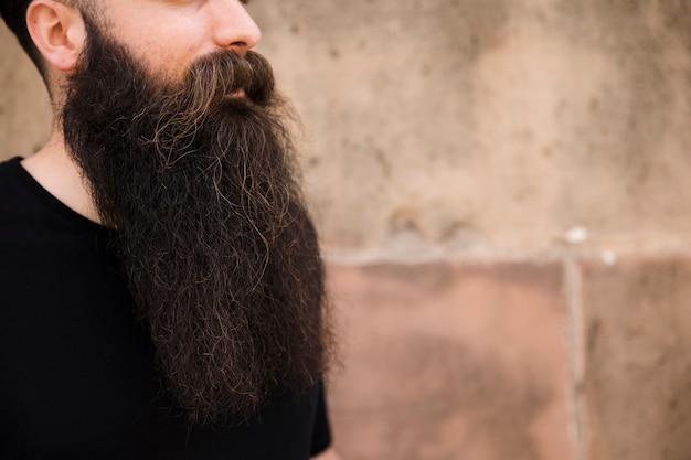 Close-up of bearded young man against wall