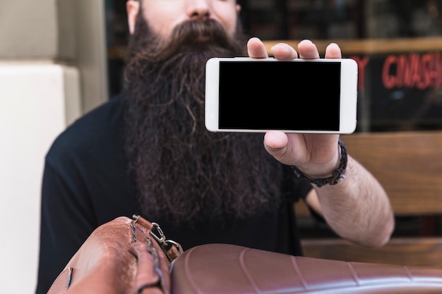 Free photo close-up of a bearded young man showing mobile phone screen