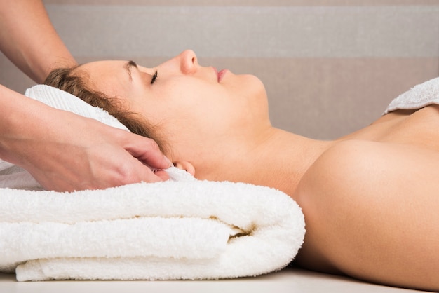 Free photo close-up of a beautician's hand wrapping towel on woman's head