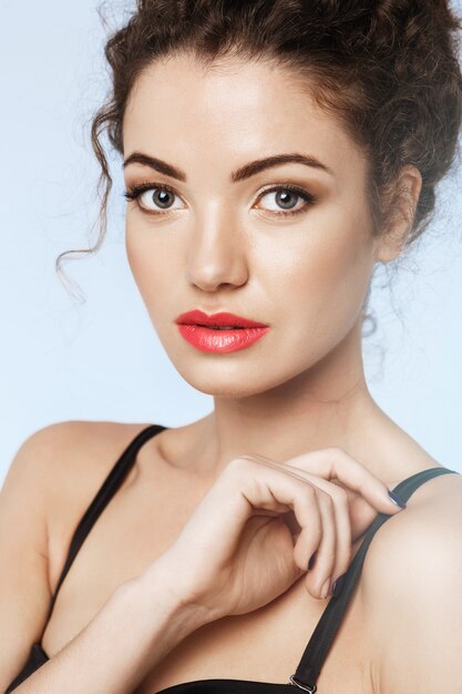 Close up of beautiful girl with bright makeup . blue wall