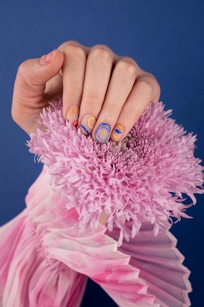 Free Photo close up beautiful manicure holding purple flower