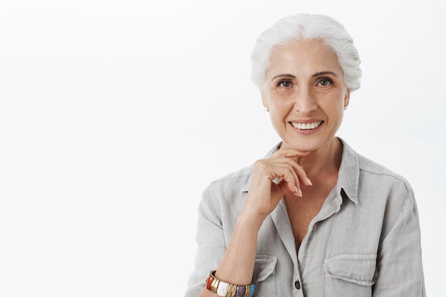 Close-up of beautiful smiling old lady looking pleased and interested