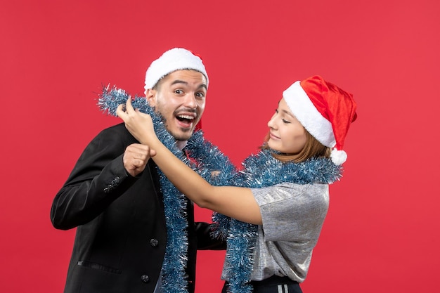 Free photo close up on beautiful young couple wearing santa hats isolated