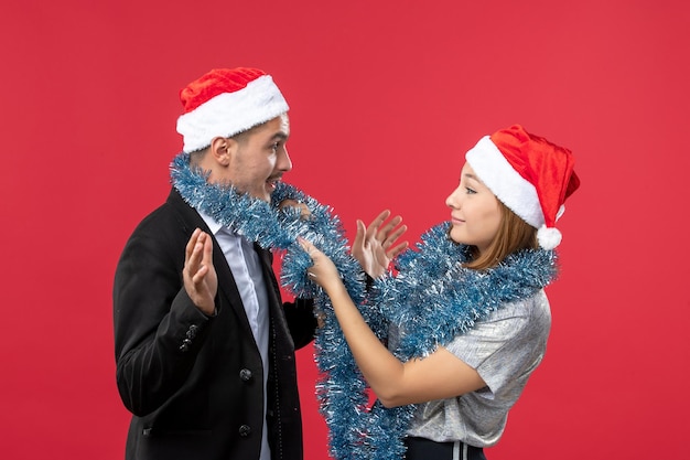 Free photo close up on beautiful young couple wearing santa hats isolated