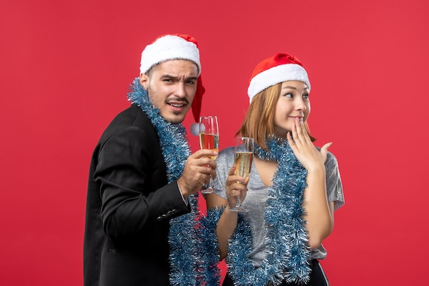 Close up on beautiful young couple wearing Santa hats isolated