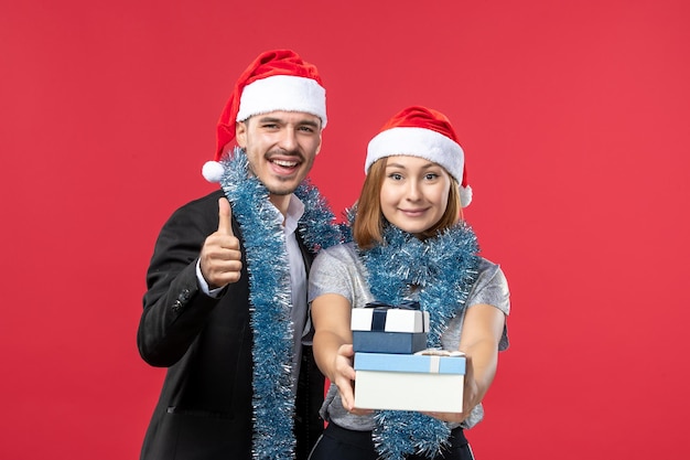 Close up on beautiful young couple wearing Santa hats isolated