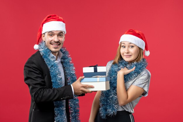 Close up on beautiful young couple wearing Santa hats isolated