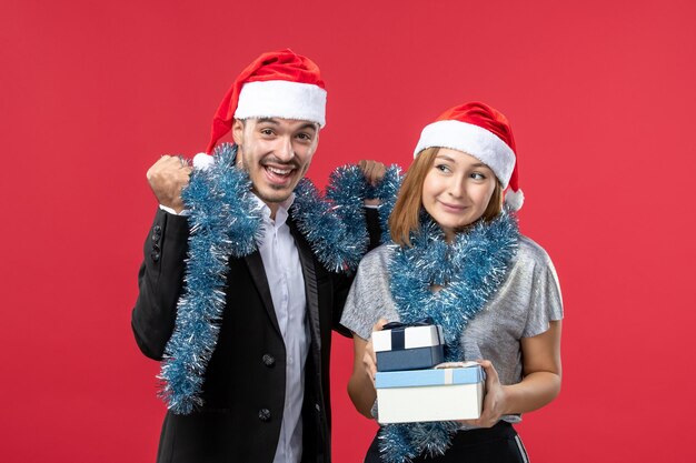 Close up on beautiful young couple wearing Santa hats isolated