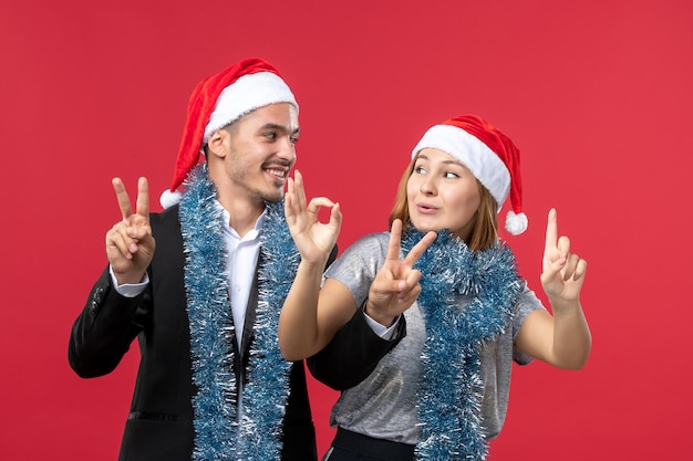 Free photo close up on beautiful young couple wearing santa hats isolated