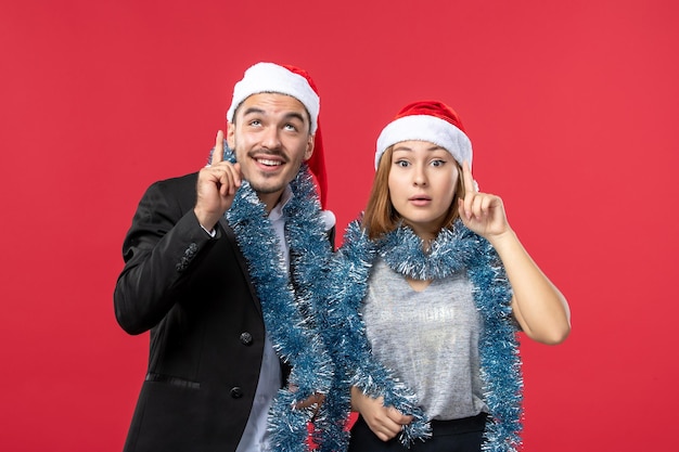 Close up on beautiful young couple wearing Santa hats isolated