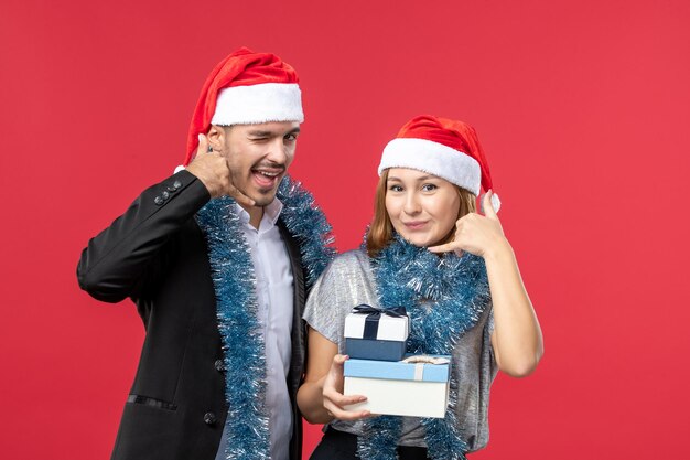 Free photo close up on beautiful young couple wearing santa hats isolated