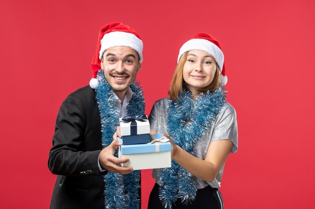 Close up on beautiful young couple wearing Santa hats isolated