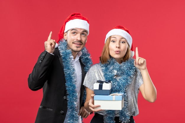 Free photo close up on beautiful young couple wearing santa hats isolated