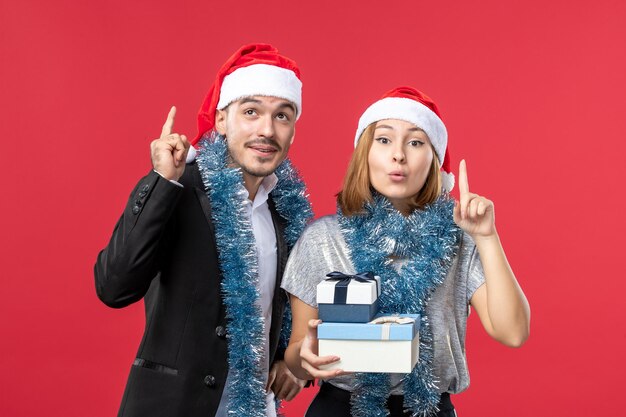 Close up on beautiful young couple wearing Santa hats isolated