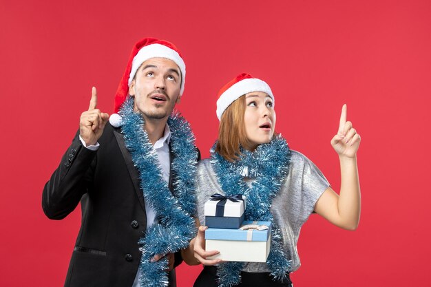 Close up on beautiful young couple wearing Santa hats isolated