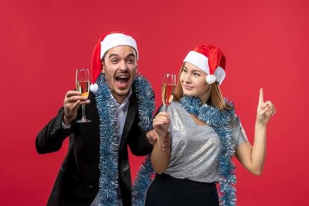 Free photo close up on beautiful young couple wearing santa hats isolated