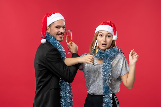 Free photo close up on beautiful young couple wearing santa hats isolated