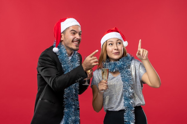 Close up on beautiful young couple wearing Santa hats isolated