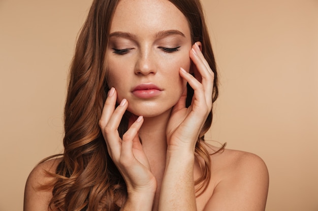 Free photo close up beauty portrait of sensual ginger woman with long hair posing with arms near the face