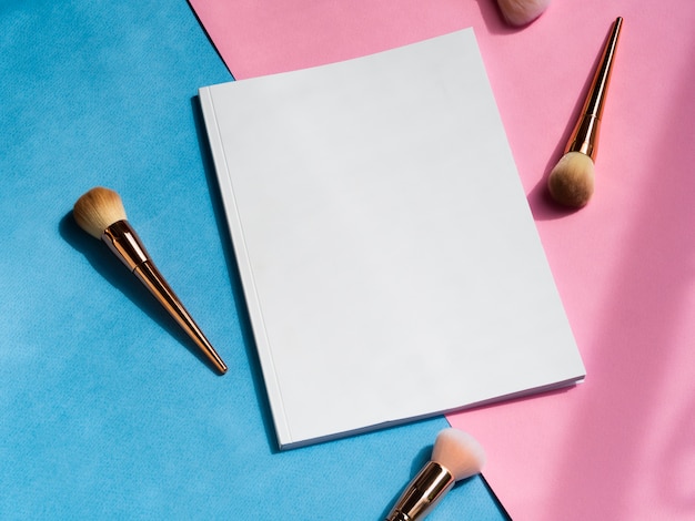 Free photo close-up blank magazine with makeup brushes