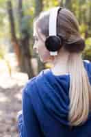 Free photo close-up of blonde girl listening to music outdoors