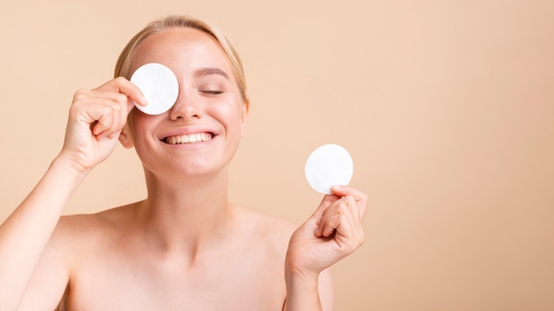 Close-up blonde model with cotton pads