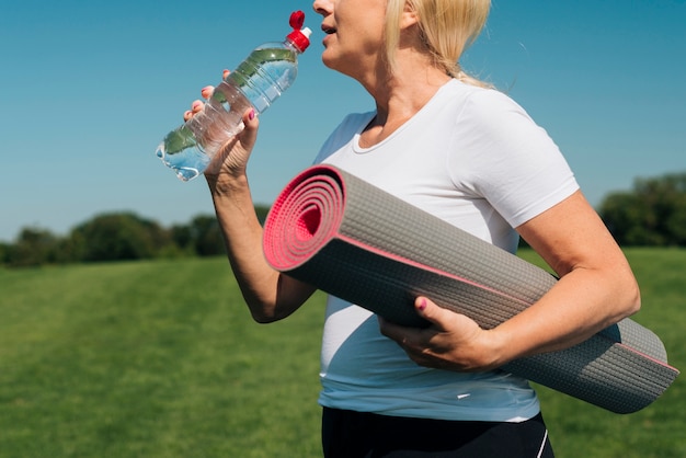 Close-up blonde woman drinking water