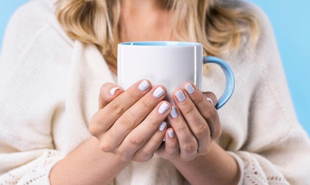 Close-up blonde woman holding a mug