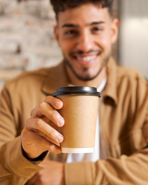 Free photo close up blurry man holding cup