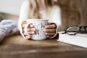 Free photo close up blurry woman holding mug