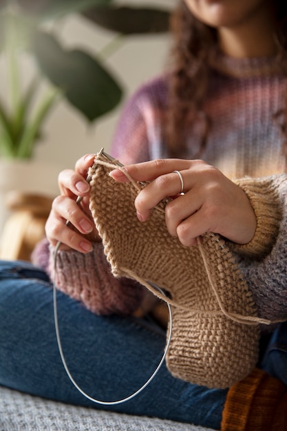 Close up blurry woman knitting at home