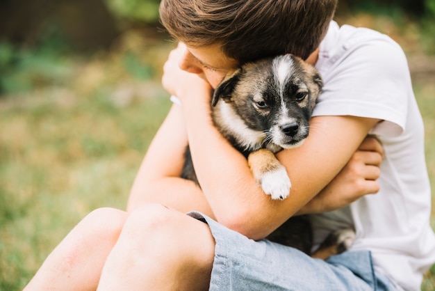 Free Photo close-up of boy embracing his lovely puppy