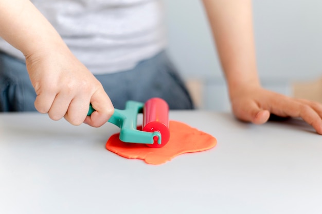 Free photo close-up boy playing with plasticine