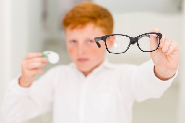 Free photo close-up of boy showing black frame eyeglasses