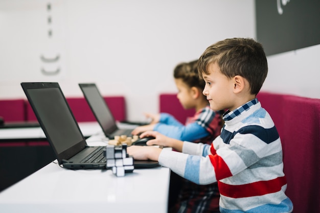 Free Photo close-up of boy using laptop in the classroom