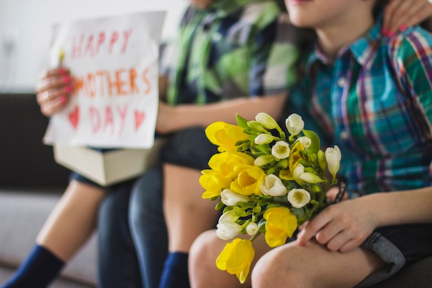 Free photo close-up of boy with bouquet for his mother