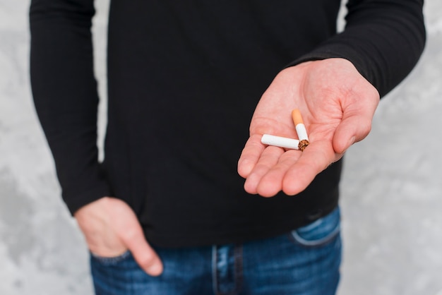 Close-up of broken cigarette in hand