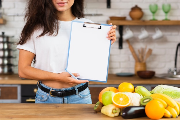 Close-up brunette woman holding up a clipboard