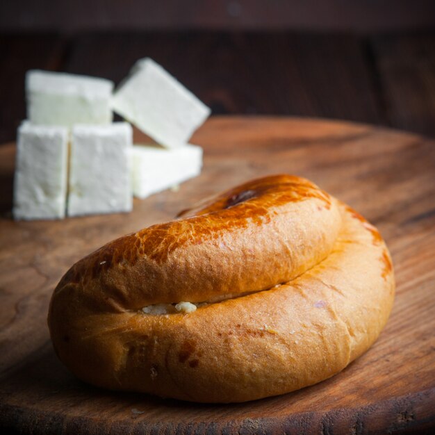 Close-up bun on wooden cutting board with cheese