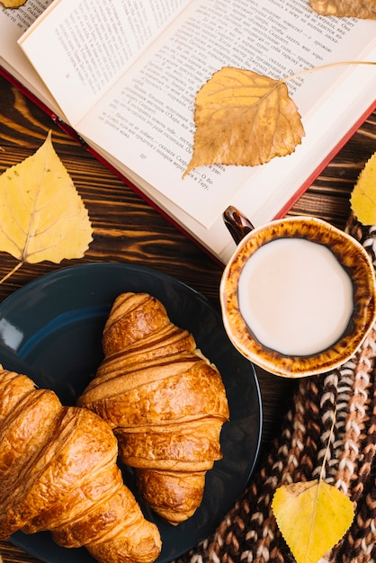 Free Photo close-up buns and milk near book and leaves