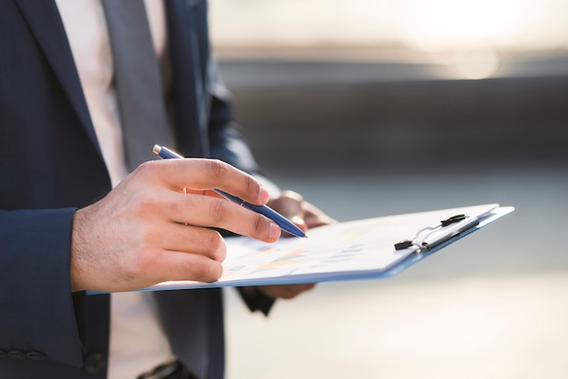 Close-up business man checking clipboard