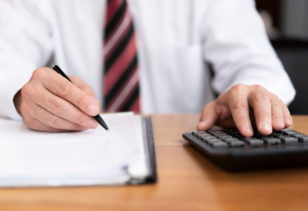 Close up business man using calculator