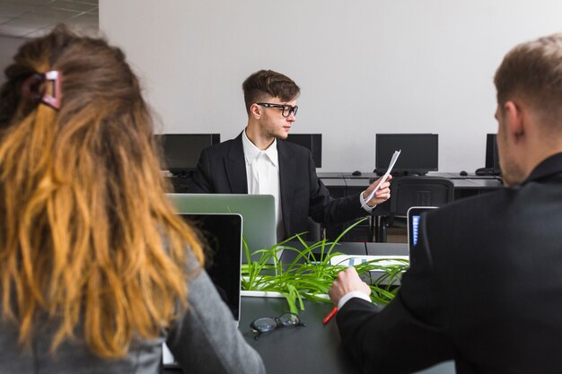 Close-up of business partner sitting in front of manager looking at document