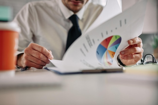 Free Photo close up of businessman analyzing statistics while reading charts in the office copy space